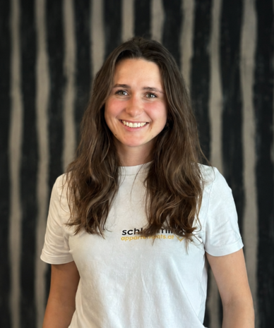 Smiling woman with long brown hair wearing white t-shirt