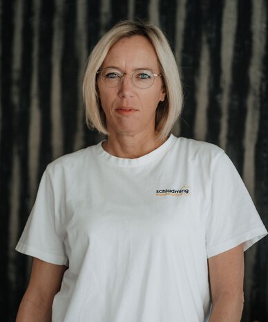 Portrait of a woman with short blonde hair wearing glasses