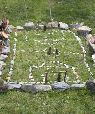 Rectangular rock garden with border stones on grass