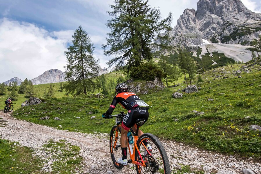 Mountain biker riding along rocky alpine trail