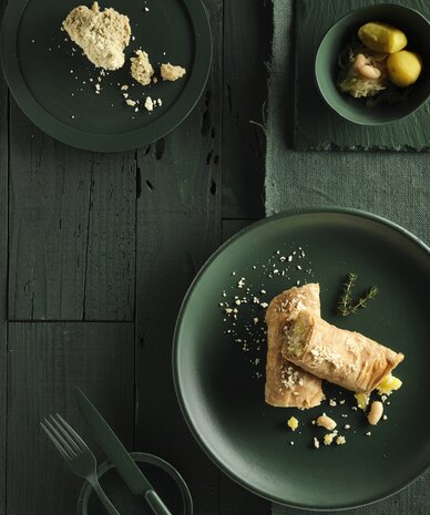 Green table setting with pastry rolls and vegetable bowl | © RAPHAELGABAUER.COM