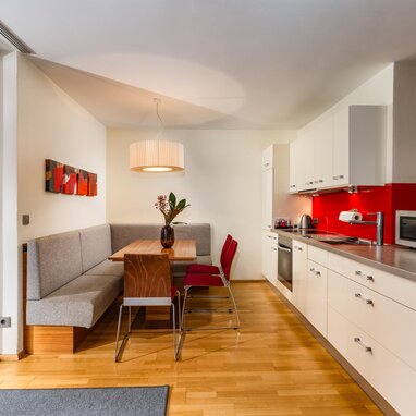 Open-plan kitchen and dining area with red backsplash