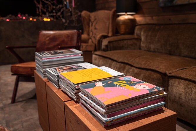 Stack of magazines on a wooden coffee table.