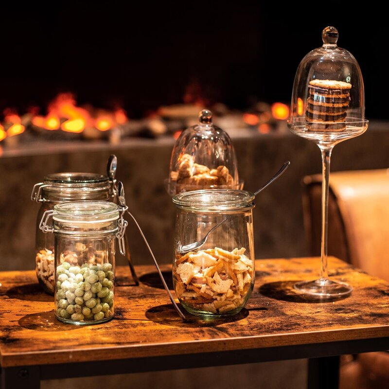 Jars of snacks and cookies on a wooden table.