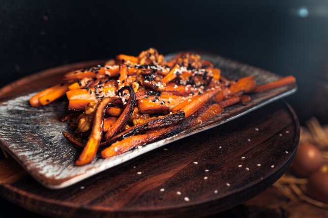 Roasted carrot sticks with sesame seeds on a plate | © TIEBER