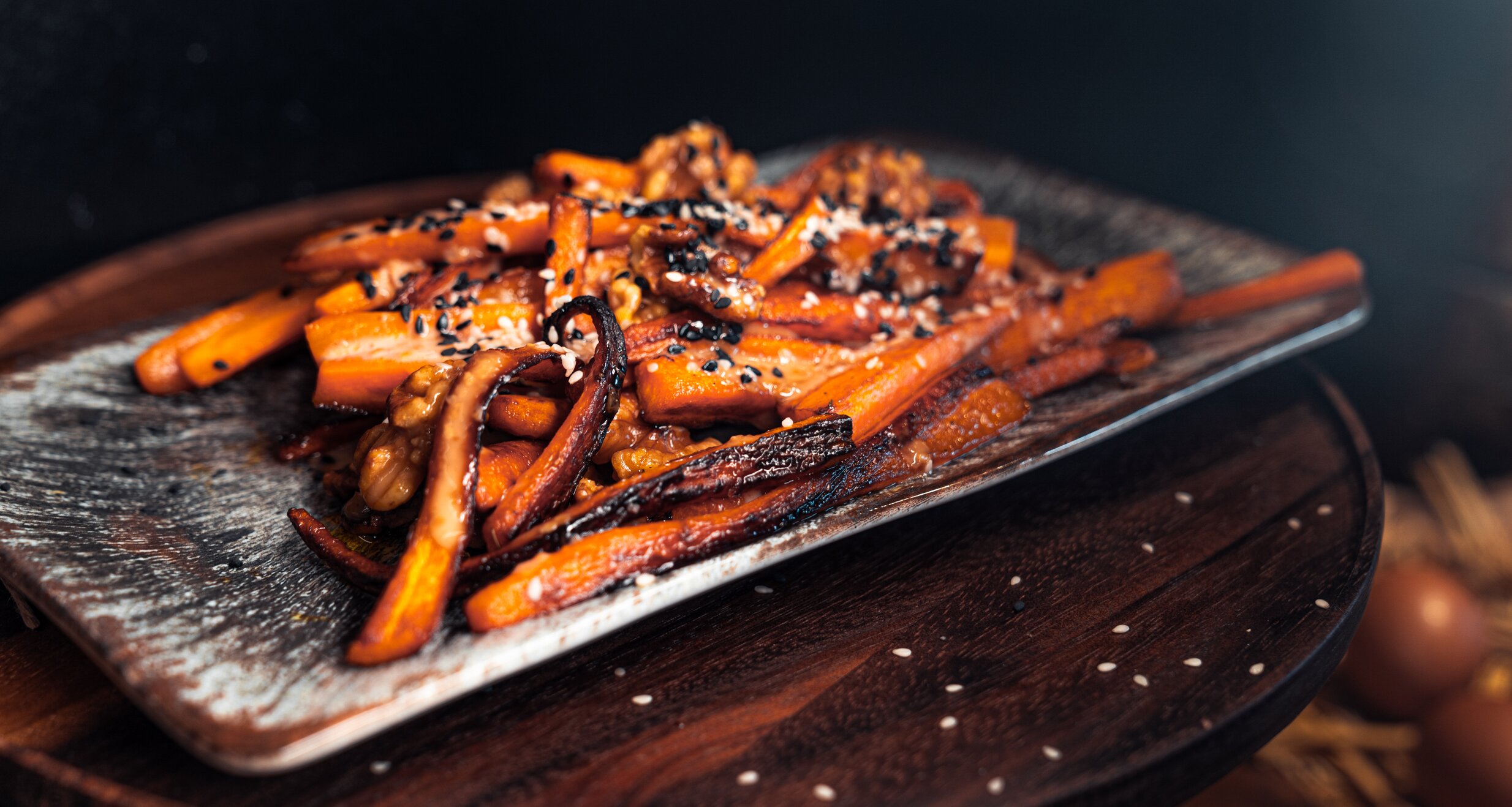 Roasted carrot sticks with sesame seeds on a plate | © TIEBER