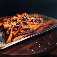 Roasted carrot sticks with sesame seeds on a plate | © TIEBER