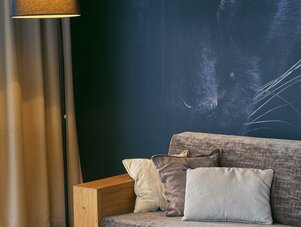 Living room with dark blue wall and cat mural
