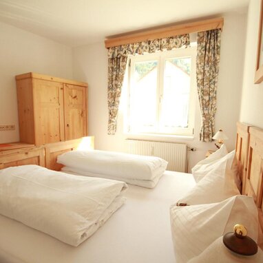 Cozy wooden bedroom with two beds and wardrobe