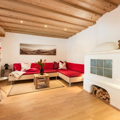 Cozy living room with red sofas, wooden armoire, and stove