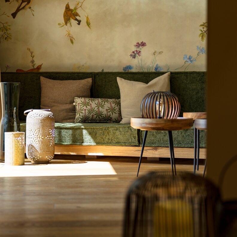 Cozy living room with green sofa, cushions, and lanterns