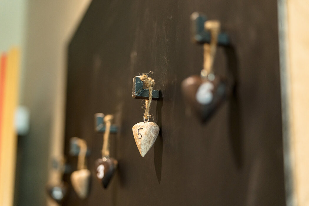 Close-up of hanging heart-shaped stones labeled 5 against a dark background