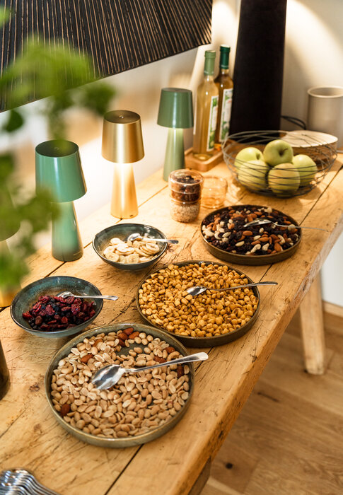 Wooden table with bowls of mixed nuts and dried fruits