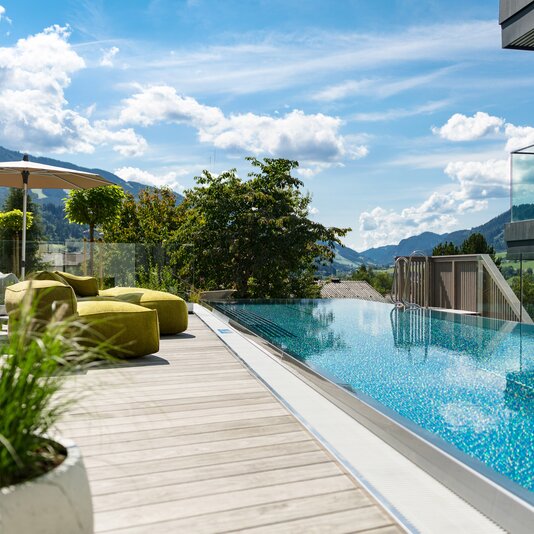 Rooftop pool with lounge chairs and mountain view