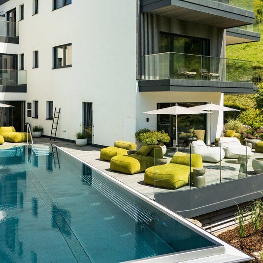 Modern apartment complex with outdoor pool and lounge area