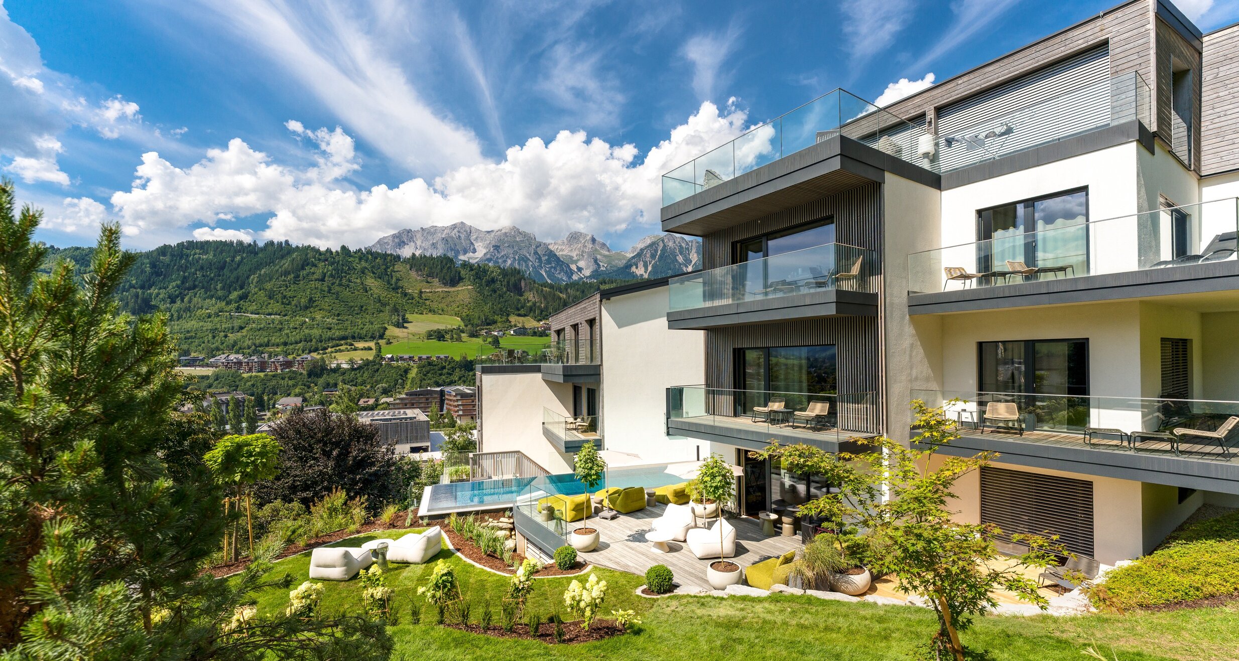 Modern apartment building with balconies and green hills