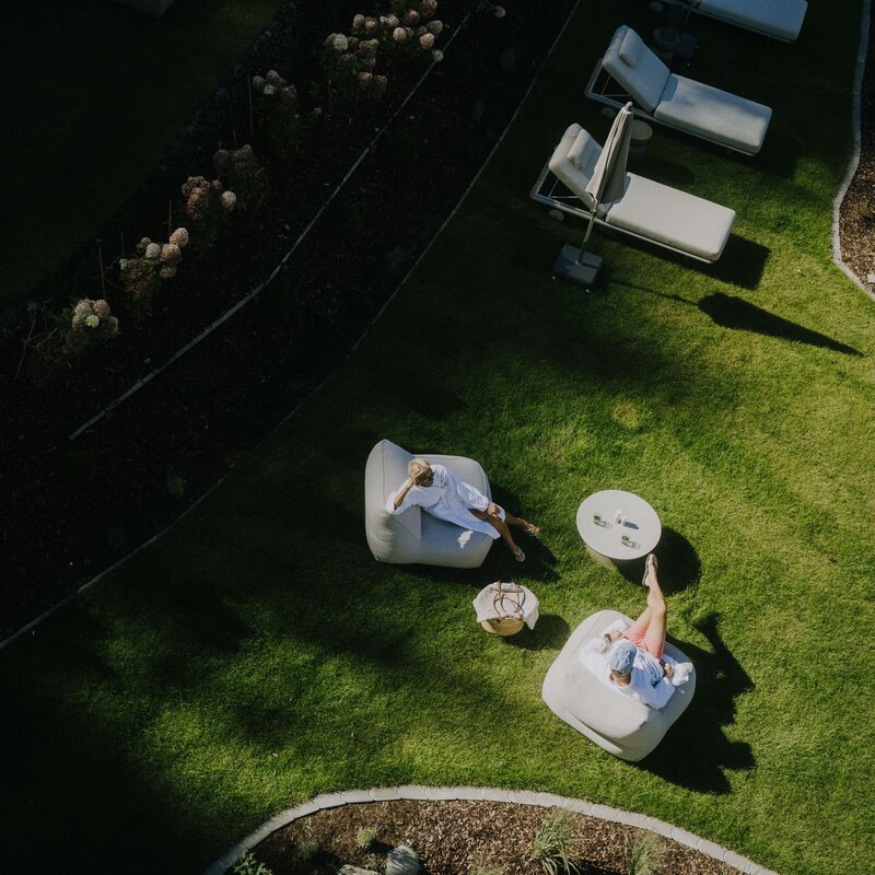 Aerial view of two people relaxing on lounge chairs in a garden