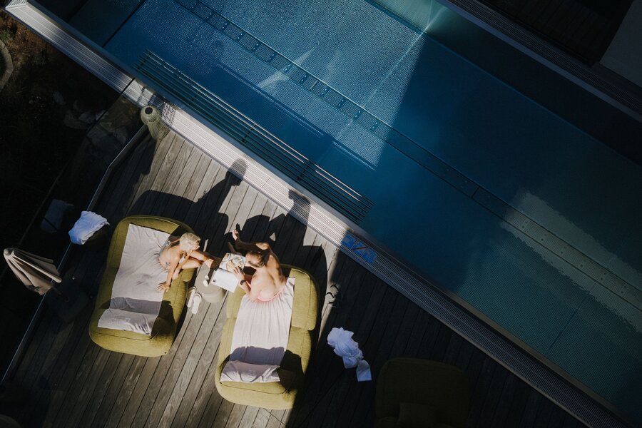 Aerial view of two people lounging by the pool