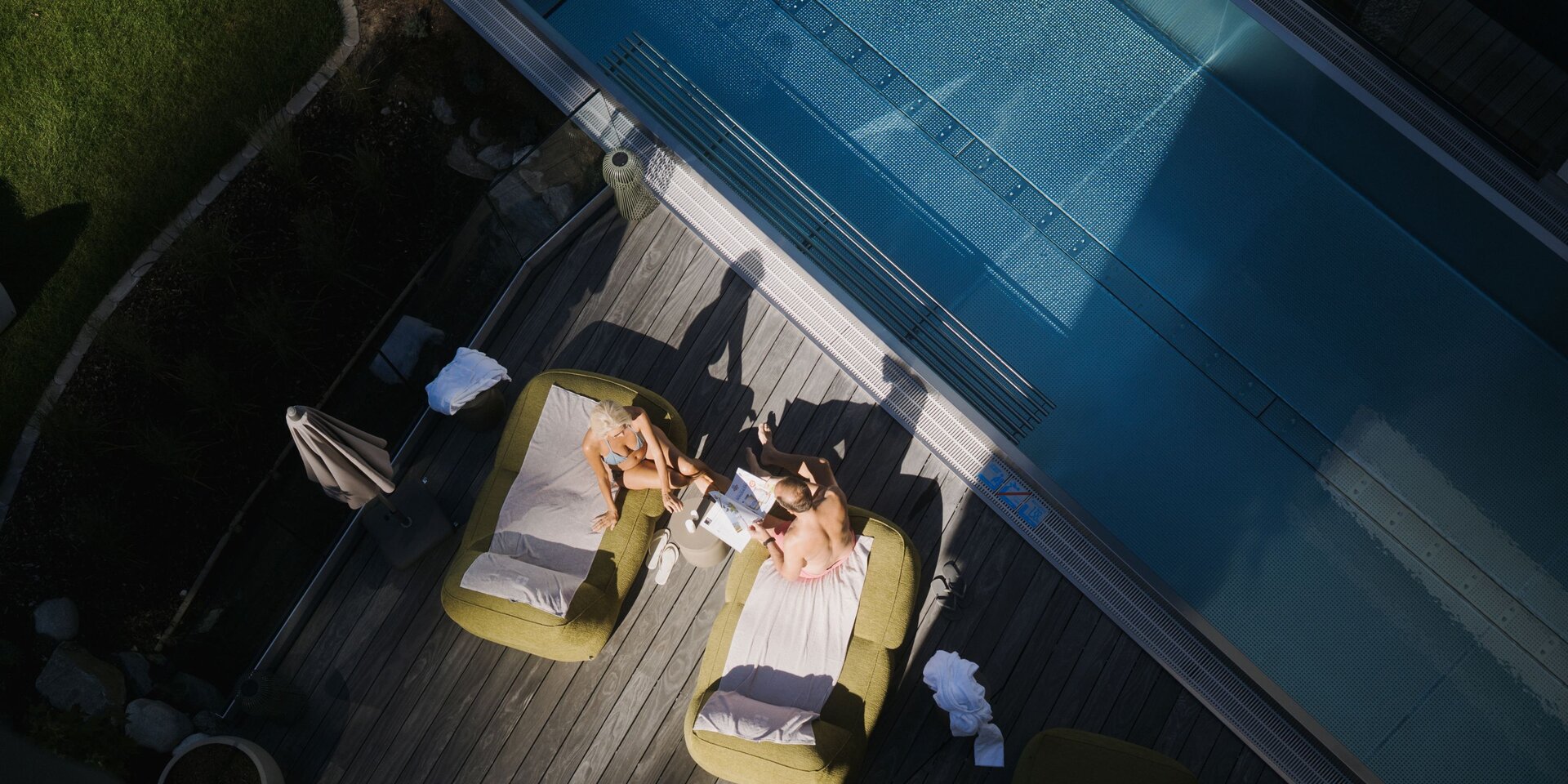 Aerial view of pool deck with two sunbathing loungers