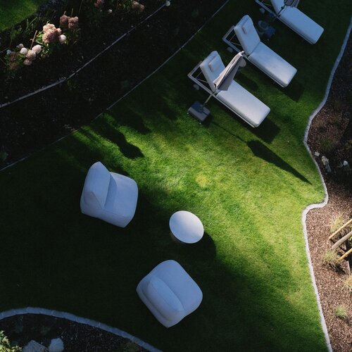 Aerial view of a garden lawn with white lounge chairs