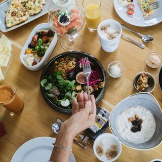Overhead view of varied breakfast spread with cheese, bread, salad