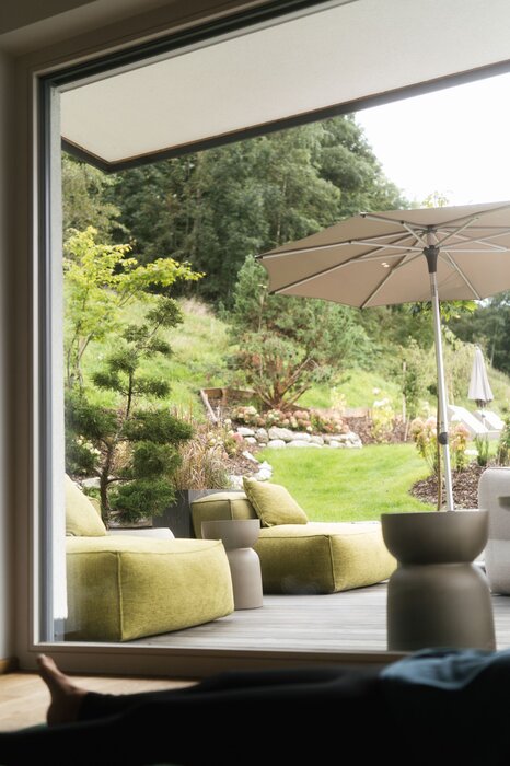 Indoor view of outdoor patio with green cushioned seating
