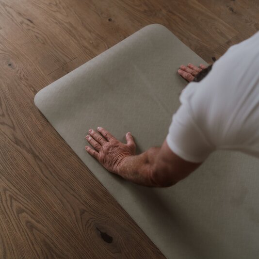 Person performs a push-up on a light green yoga mat