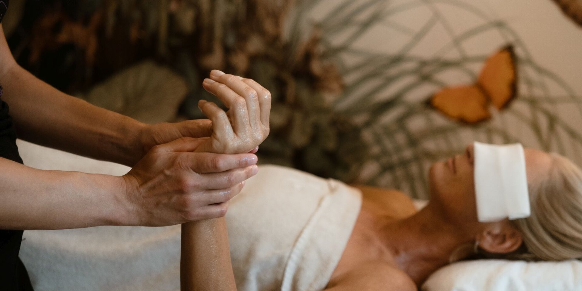 Therapist massages a client's hand during spa treatment