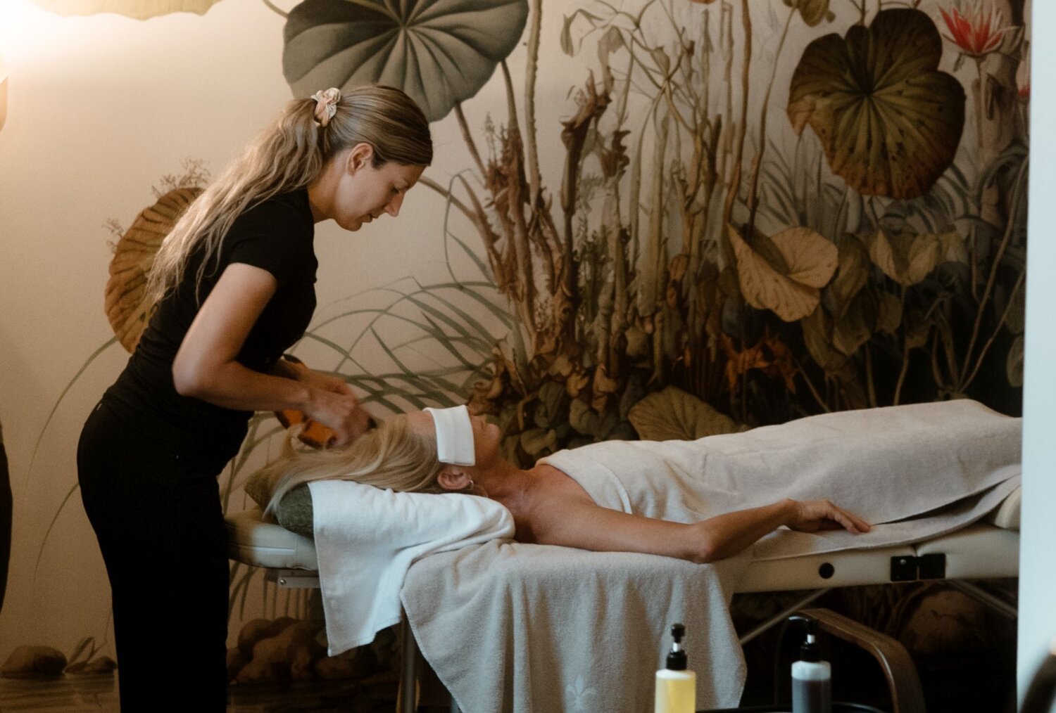 Therapist performs treatment on client lying on massage table
