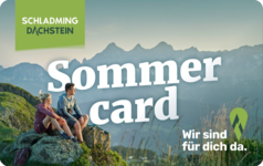 Two hikers sit on a rock with Sommer card text in mountains.